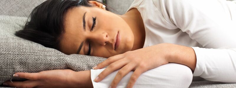 Junge Frau schläft auf der Couch