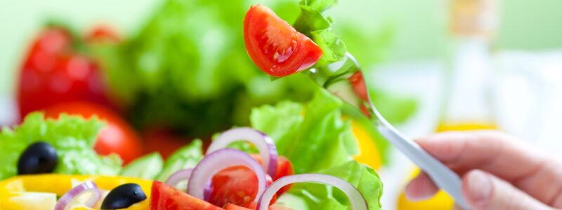 grüner Salat mit Tomaten, Paprika, Oliven und Zwiebelringen