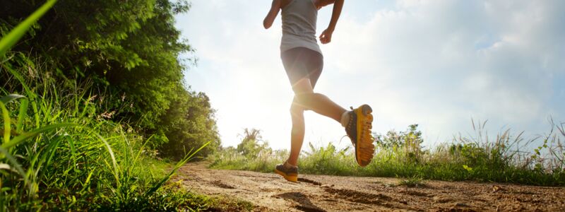 Junge Frau joggt auf einem Waldweg