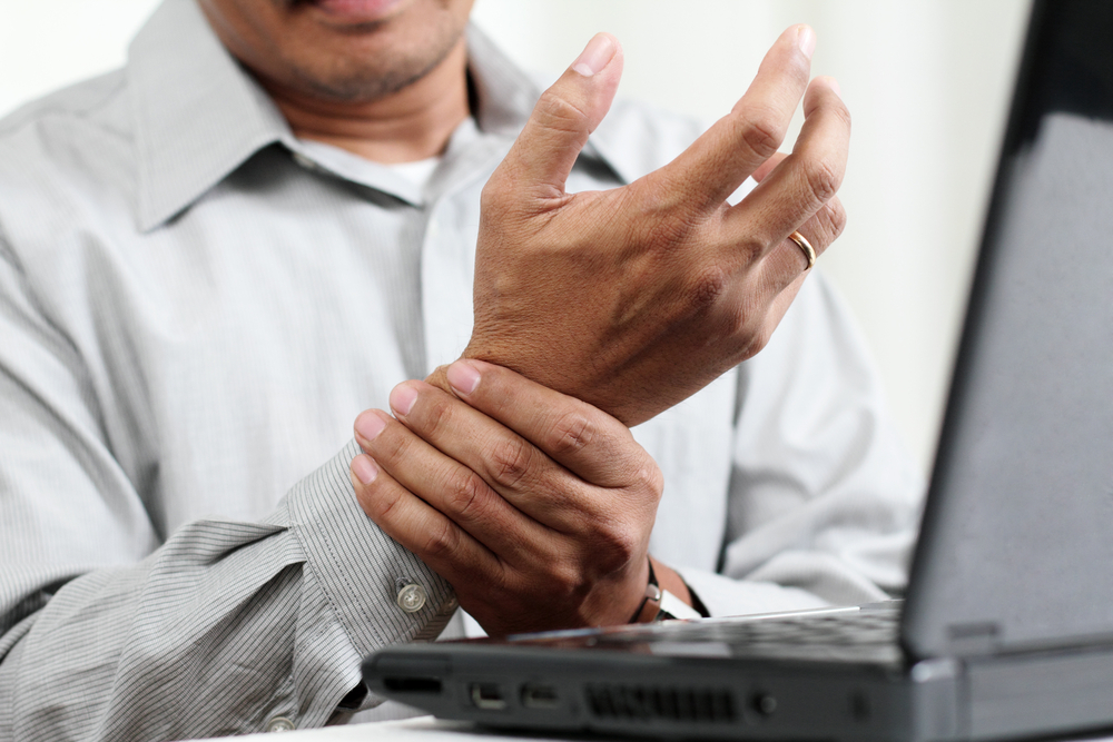 Mann mit Gelenkschmerzen in der Hand